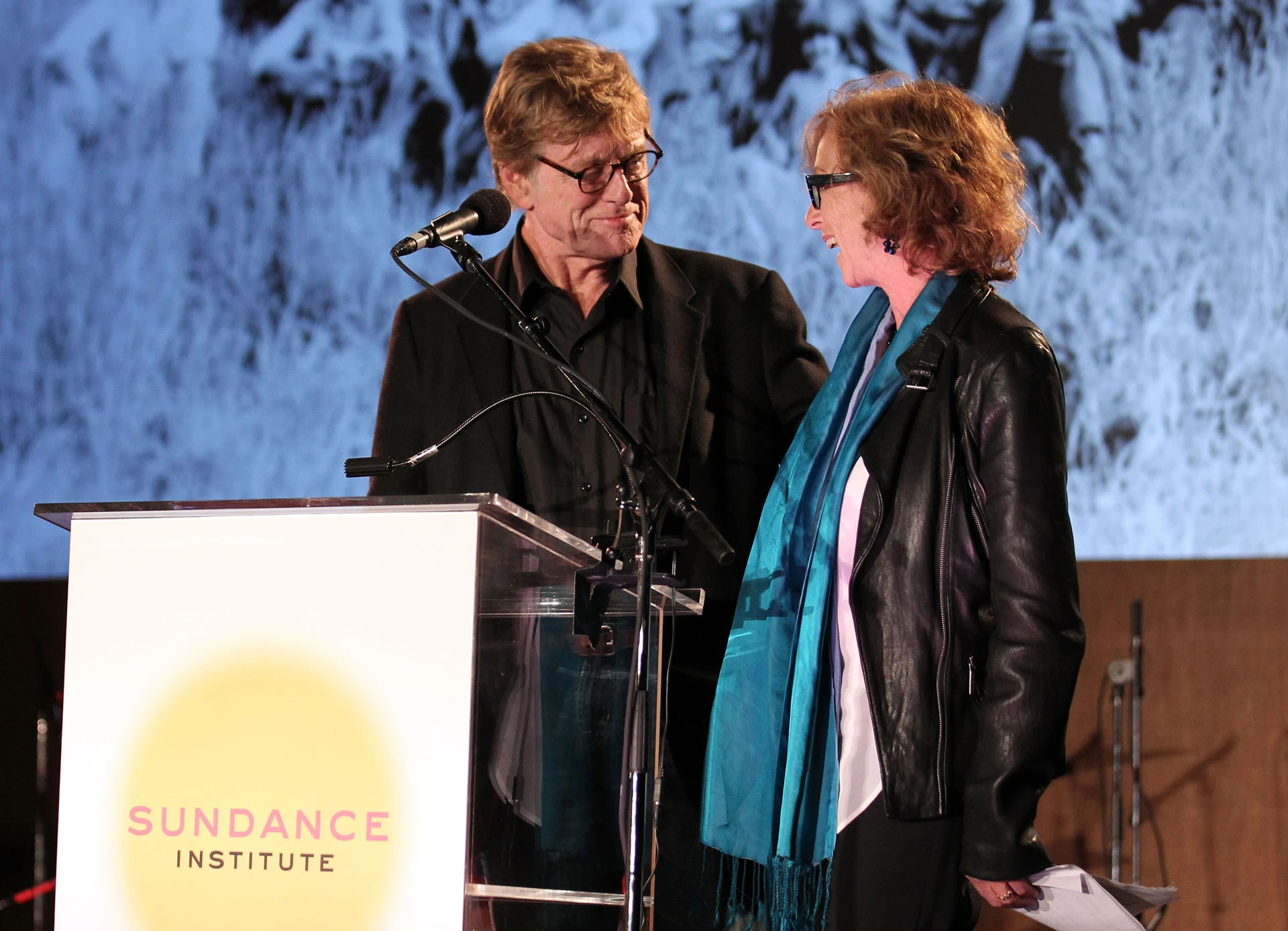 Президент и основатель Института Сандэнс Роберт Редфорд и почетный директор Мишель Саттер выступают на сцене благотворительного вечера «В честь Института Сандэнс» в Лос-Анджелесе 8 июня 2011 года в Беверли-Хиллз, Калифорния | Getty Images