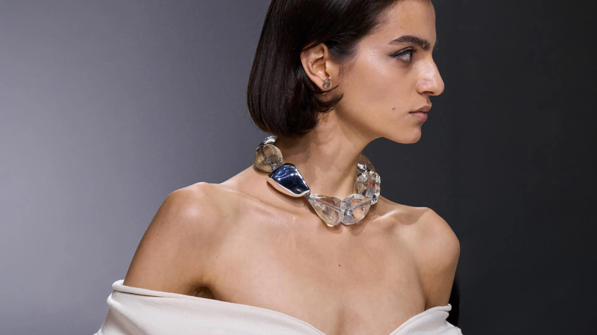 В своей дебютной коллекции для Bottega Veneta Луиз Троттер наряду с культовым intrecciato активно работает со стекловолокном, создавая искрящиеся платья и свитеры, и акриловой смолой для аксессуаров. Массивные полупрозрачные колье превращают даже самый простой образ в вечерний, подтверждая, что украшения с приставкой statement окончательно вернулись в наш гардероб | Архив пресс-службы